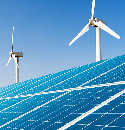 Produkte und Services für eine nachhaltigere Welt Großes Solarpanel vor Reihe weißer Windräder unter klarem blauem Himmel.
