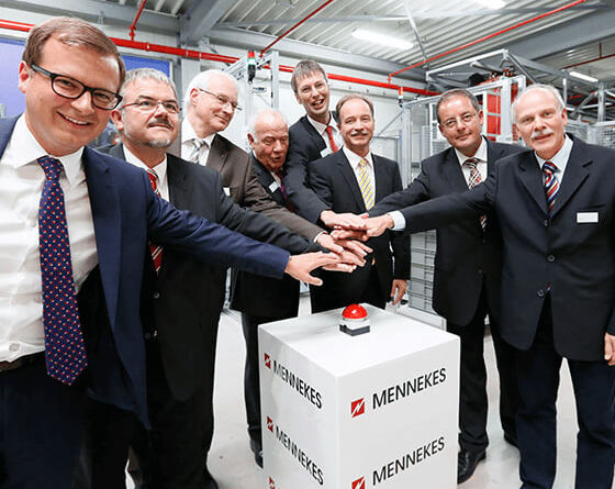 Acht Personen drücken gemeinsam auf einen roten Buzzer